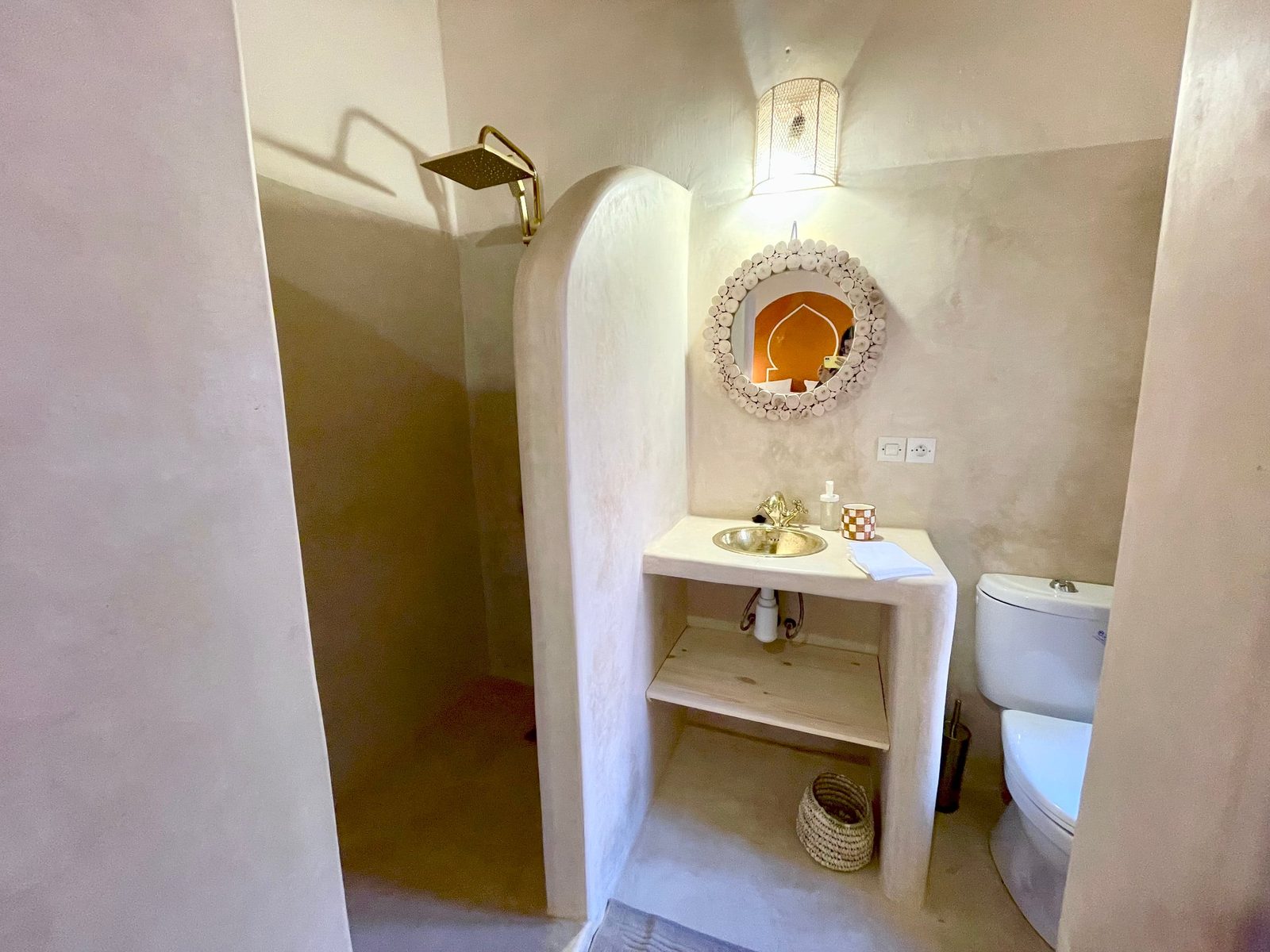 La vasque en tadelakt de la Chambre Rouge, miroir rond et poteries
