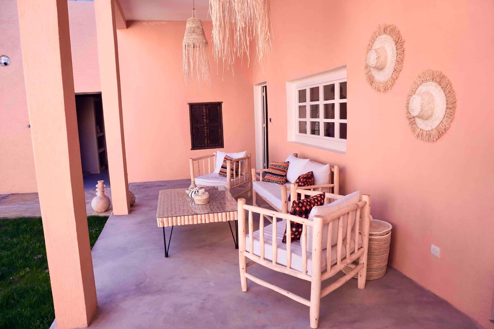Les banquettes du salon extérieur sous les arcades roses de Dar Djinou